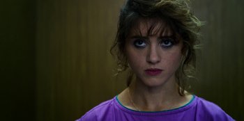 Movie still from “Stranger Things” (2016), created by Ross Duffer – A person wearing a purple shirt; Close Up shot, Over the shoulder angle