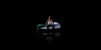 Movie still from “Stranger Things” (2016), created by Ross Duffer – A person sitting on a bed in a dark room; Wide shot, Overhead angle