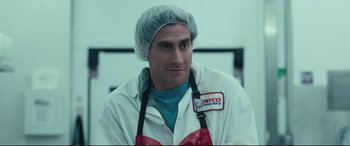 Movie still from “Stronger” (2017), directed by David Gordon Green – A man wearing a white lab coat and a blue apron; Close Up shot, Over the shoulder angle