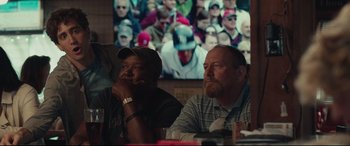 Movie still from “Stronger” (2017), directed by David Gordon Green – A couple of men sitting next to each other at a table; Medium shot, Over the shoulder angle