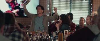 Movie still from “Stronger” (2017), directed by David Gordon Green – A group of people sitting at a table with drinks; Medium shot, Low angle