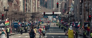 Movie still from “Stronger” (2017), directed by David Gordon Green – A group of people walking down a street under traffic lights; Extreme Wide shot, High angle