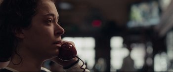 Movie still from “Stronger” (2017), directed by David Gordon Green – A woman holding an apple in her hand and talking on the phone; Close Up shot, Low angle