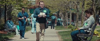 Movie still from “Stronger” (2017), directed by David Gordon Green – A man walking down a sidewalk while holding a cup of coffee; Medium shot, Over the shoulder angle