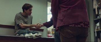 Movie still from “Stronger” (2017), directed by David Gordon Green – Two people shaking hands in a room; Medium shot, Over the shoulder angle