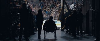 Movie still from “Stronger” (2017), directed by David Gordon Green – A man sitting in a chair in front of a crowd; Wide shot, High angle