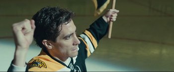 Movie still from “Stronger” (2017), directed by David Gordon Green – A man in a hockey uniform holding a stick in the air; Close Up shot, Low angle