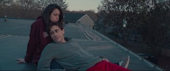 Movie still from “Stronger” (2017), directed by David Gordon Green – A man and a woman laying on the roof of a house; Medium shot, Low angle