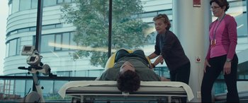Movie still from “Stronger” (2017), directed by David Gordon Green – A man laying on a bed while a woman stands over him; Wide shot, Over the shoulder angle