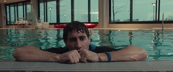 Movie still from “Stronger” (2017), directed by David Gordon Green – A man laying on the edge of a swimming pool; Close Up shot, Low angle