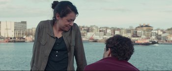 Movie still from “Stronger” (2017), directed by David Gordon Green – A woman standing next to a man near a body of water; Medium shot, Over the shoulder angle