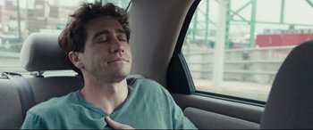 Movie still from “Stronger” (2017), directed by David Gordon Green – A man sitting in the back of a car with his eyes closed; Close Up shot, Over the shoulder angle