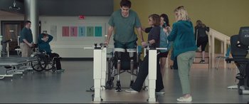 Movie still from “Stronger” (2017), directed by David Gordon Green – A man in a wheel chair using a rowing machine while people watch; Wide shot, Over the shoulder angle