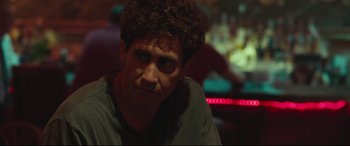 Movie still from “Stronger” (2017), directed by David Gordon Green – A man with curly brown hair sitting in a room; Close Up shot, Over the shoulder angle
