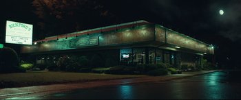 Movie still from “Stronger” (2017), directed by David Gordon Green – A building that is lit up at night time; Extreme Wide shot, Low angle