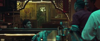 Movie still from “Stronger” (2017), directed by David Gordon Green – A man sitting at a table in front of a bar; Medium shot, Over the shoulder angle