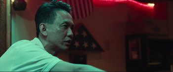 Movie still from “Stronger” (2017), directed by David Gordon Green – A person in a room with a flag in the background; Close Up shot, Low angle