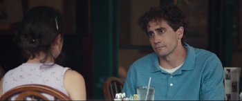 Movie still from “Stronger” (2017), directed by David Gordon Green – A man sitting at a table with a drink in front of him; Close Up shot, Over the shoulder angle