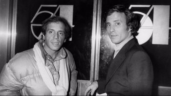A black and white photo of two men standing next to each other