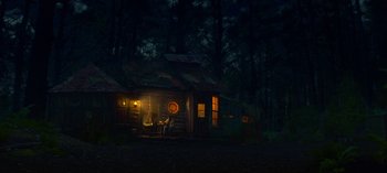 Movie still from “Sweet Tooth” (2021), created by Jim Mickle – A log cabin in the woods at night with lights on; Extreme Wide shot, Low angle