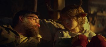 Movie still from “Sweet Tooth” (2021), created by Jim Mickle – A man and a woman sitting next to each other on a couch; Close Up shot, Over the shoulder angle