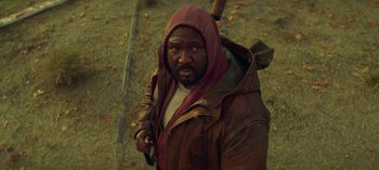 Movie still from “Sweet Tooth” (2021), created by Jim Mickle – A man in a hooded jacket holding a rifle; Close Up shot, Low angle