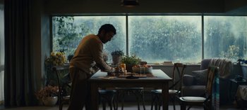 Movie still from “Sweet Tooth” (2021), created by Jim Mickle – A man standing at a dining room table with food; Wide shot, Low angle