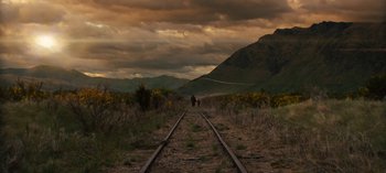 Movie still from “Sweet Tooth” (2021), created by Jim Mickle – A person riding a horse down a train track; Extreme Wide shot, Low angle