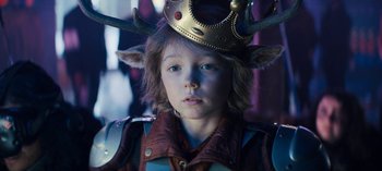 Movie still from “Sweet Tooth” (2021), created by Jim Mickle – A young boy wearing a golden crown with horns on it; Close Up shot, Over the shoulder angle