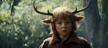 Movie still from “Sweet Tooth” (2021), created by Jim Mickle – A young boy wearing a jacket with horns on it; Close Up shot, Over the shoulder angle