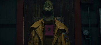 Movie still from “Sweet Tooth” (2021), created by Jim Mickle – A man in a yellow jacket and a purple hat; Medium shot, Overhead angle