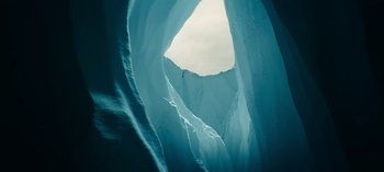 Movie still from “Sweet Tooth” (2021), created by Jim Mickle – A person is climbing up the side of an ice cave; Extreme Wide shot, Low angle