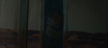 Movie still from “Sweet Tooth” (2021), created by Jim Mickle – A man with a scarf looking out of a window; Medium shot, Low angle