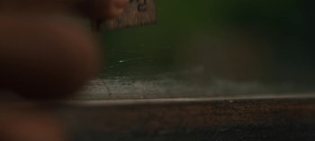 Movie still from “Sweet Tooth” (2021), created by Jim Mickle – A hand holding a wooden ruler on top of a wooden table; Extreme Close Up shot, High angle