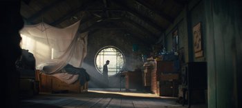 Movie still from “Sweet Tooth” (2021), created by Jim Mickle – A person standing in a room with a large round window; Wide shot, Low angle