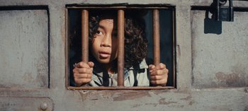 Movie still from “Sweet Tooth” (2021), created by Jim Mickle – A young girl looking out of a jail cell window; Close Up shot, Overhead angle