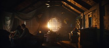 Movie still from “Sweet Tooth” (2021), created by Jim Mickle – The sun is shining through a round window in a room; Wide shot, High angle