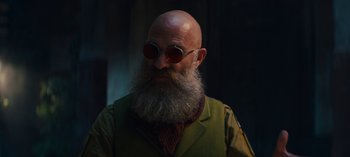 Movie still from “Sweet Tooth” (2021), created by Jim Mickle – A man with a beard and glasses is wearing a green jacket; Close Up shot, Low angle