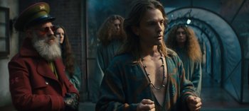 Movie still from “Sweet Tooth” (2021), created by Jim Mickle – A group of men standing next to each other on a street; Medium shot, Over the shoulder angle