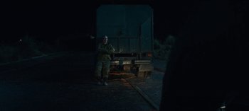 Movie still from “Sweet Tooth” (2021), created by Jim Mickle – A man standing next to a truck in the dark; Wide shot, Over the shoulder angle