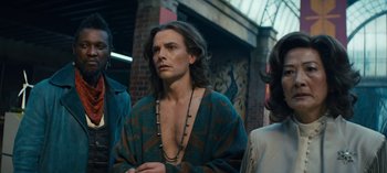 Movie still from “Sweet Tooth” (2021), created by Jim Mickle – A man with long brown hair wearing a blue and brown robe; Medium shot, Over the shoulder angle