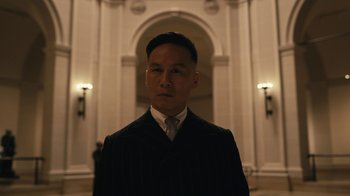 Movie still from “Mr. Robot” (2015), created by Sam Esmail – A man wearing a suit and tie standing in front of a building; Close Up shot, Low angle