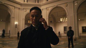 Movie still from “Mr. Robot” (2015), created by Sam Esmail – A man talking on a cell phone while wearing a suit and tie; Medium shot, Low angle