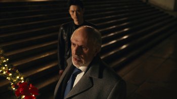 Movie still from “Mr. Robot” (2015), created by Sam Esmail – A man in a suit standing next to another man in a jacket; Medium shot, Over the shoulder angle