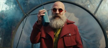 Movie still from “Sweet Tooth” (2021), created by Jim Mickle – A man in a red jacket holding up a cell phone to his ear; Medium shot, Low angle