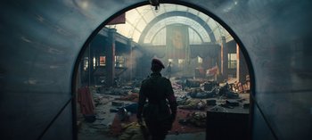 Movie still from “Sweet Tooth” (2021), created by Jim Mickle – A person in a military uniform standing in an abandoned train station; Wide shot, Low angle