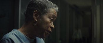 Movie still from “Synchronic” (2019), directed by Justin Benson – An older woman with short gray hair looking to her left; Close Up shot, Over the shoulder angle