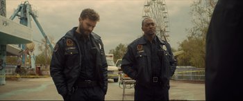 Movie still from “Synchronic” (2019), directed by Justin Benson – A couple of men standing next to each other on a street; Medium shot, Over the shoulder angle