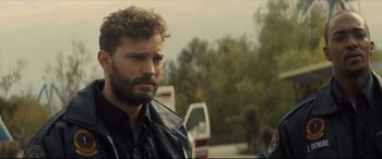 Movie still from “Synchronic” (2019), directed by Justin Benson – A person wearing a black shirt near trees; Close Up shot, Over the shoulder angle