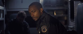 Movie still from “Synchronic” (2019), directed by Justin Benson – A man in a uniform looking to his left; Close Up shot, Over the shoulder angle